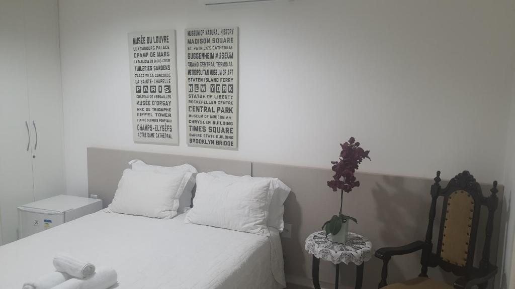 Quarto com cama de casal, orquídea e cadeira de madeira
